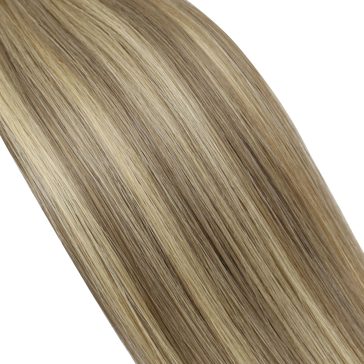 Balayage butterfly wefts transitioning from dark roots to light ends for a seamless ombre effect.